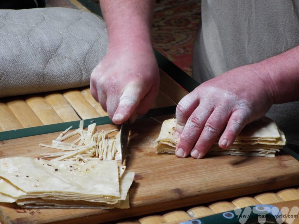 Making Tsuivan in a ger in Mongolia - cutting the noodles