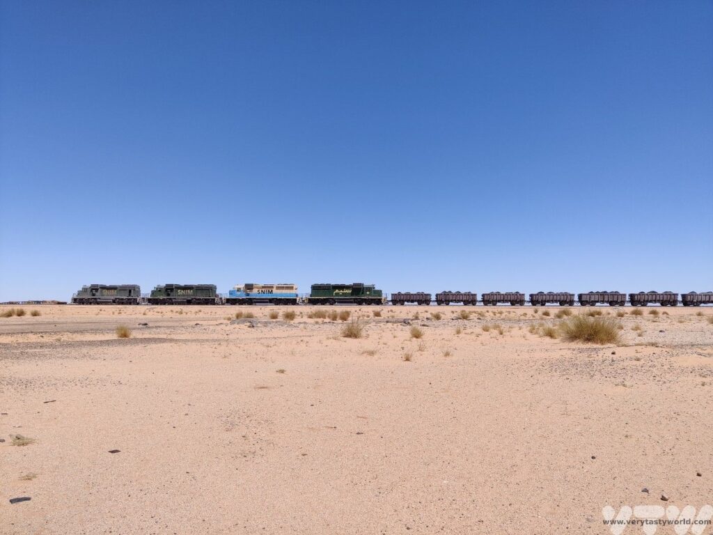 The Mauritania Iron Ore train with four diesels and multiple trucks traversing the desert