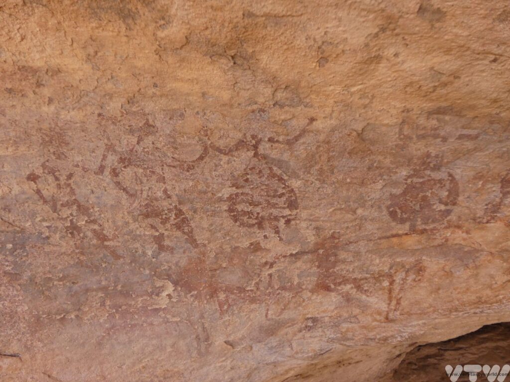 5000 year old petroglyphs showing people  dancing with their hands raised in the air