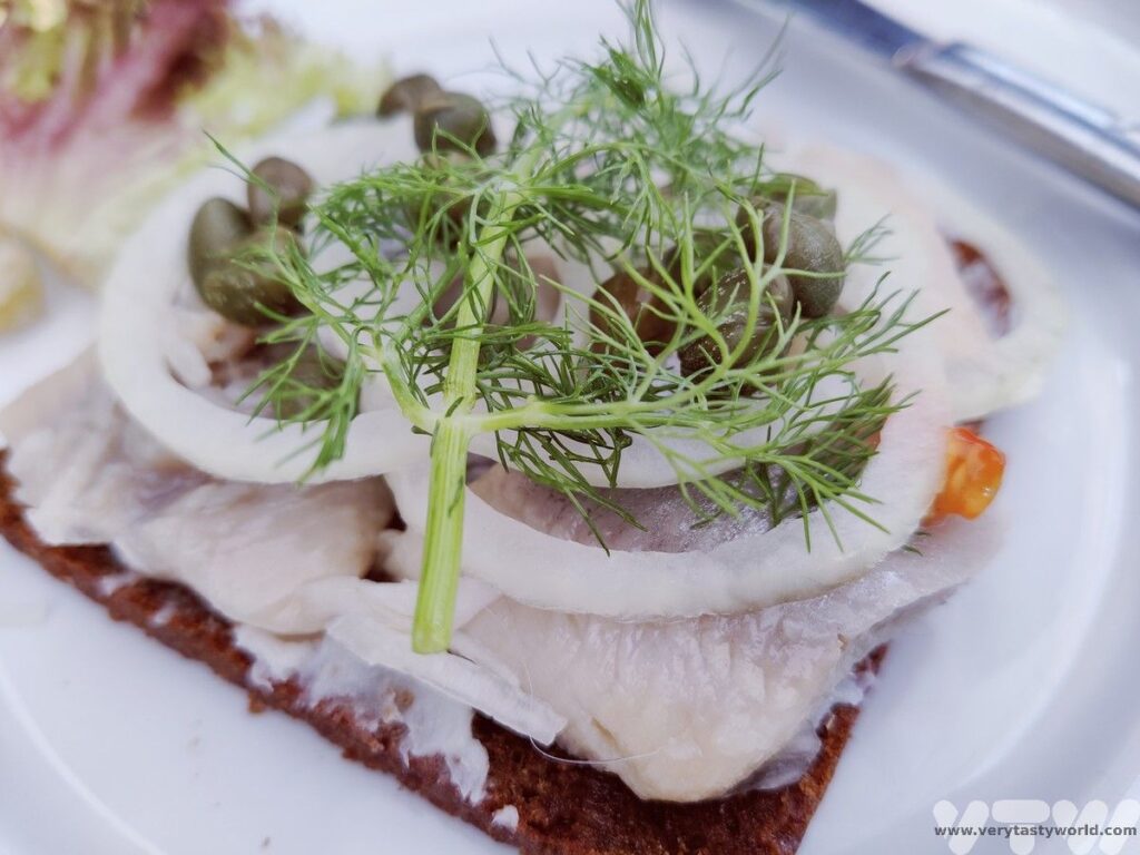 pickeld herring with onion, caper and dill open sandwich