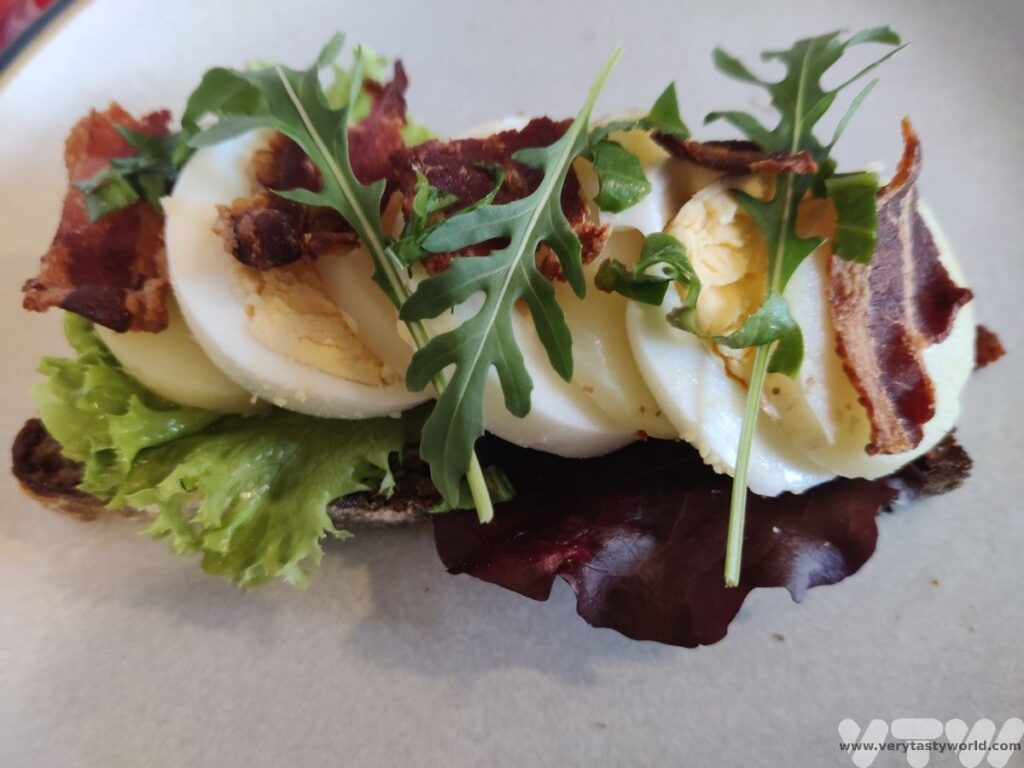 egg and bacon smorrebrod with rocket garnish