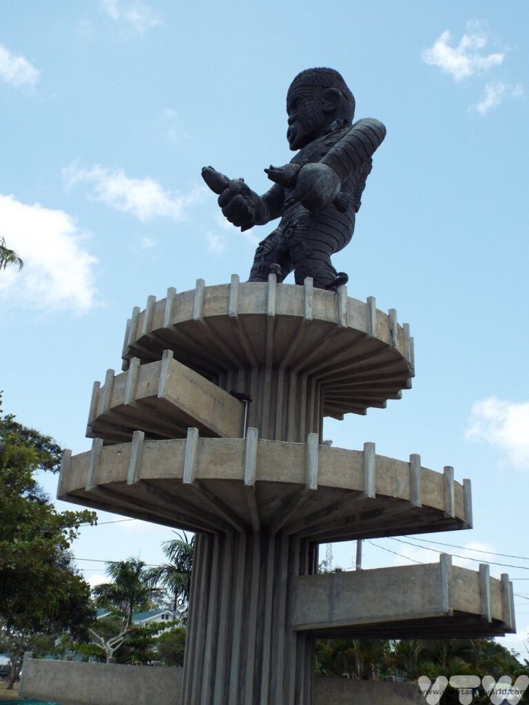 Monument of a figure grasping two fish on a large spiral plinth