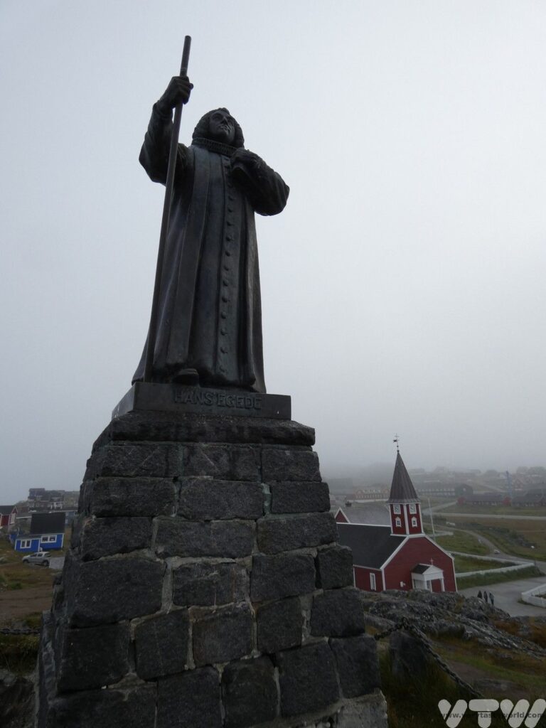 Statue of Nuuk's founder Hans Egede with church in the background