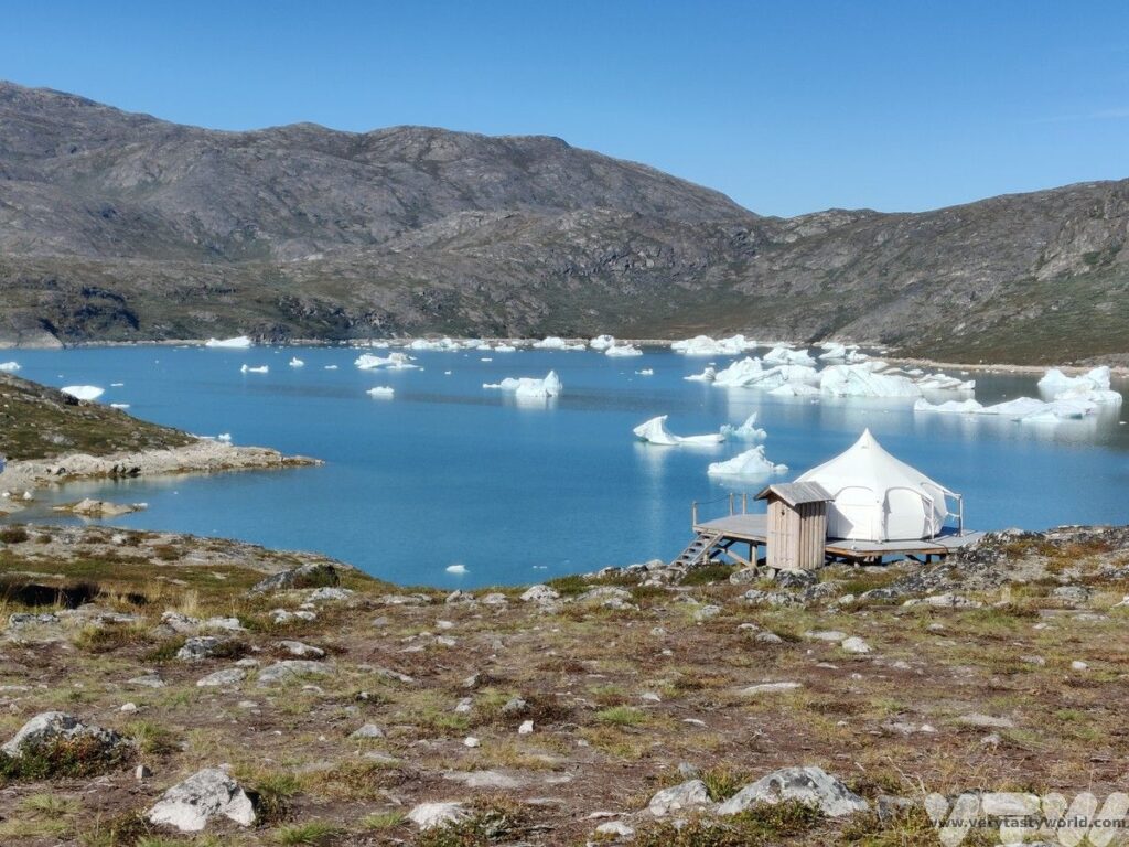 Camp Kangiusaq tent overlooking iceberg filled lagoon